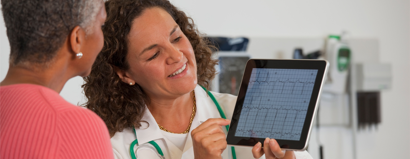 Photo of doctor showing patient tablet screen