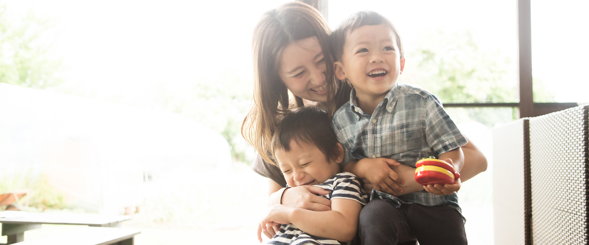 A mother playing with her two small children.
